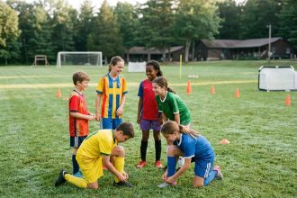 Groupe de jeunes footballeurs souriants sur le terrain