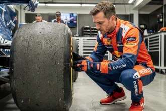 Mécanicien F1 inspectant un pneu en garage lors des préparatifs de course 2026